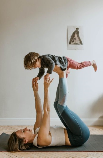 Mom and child doing yoga on a mat (MODELS)